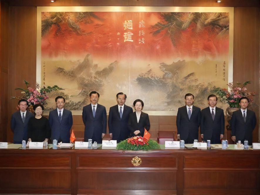 一群朋友在珠海一家装饰温馨的咖啡馆里,围坐在一起,手里拿着咖啡杯,轻松愉快地聊天,背景是柔和的灯光和舒适的沙发。